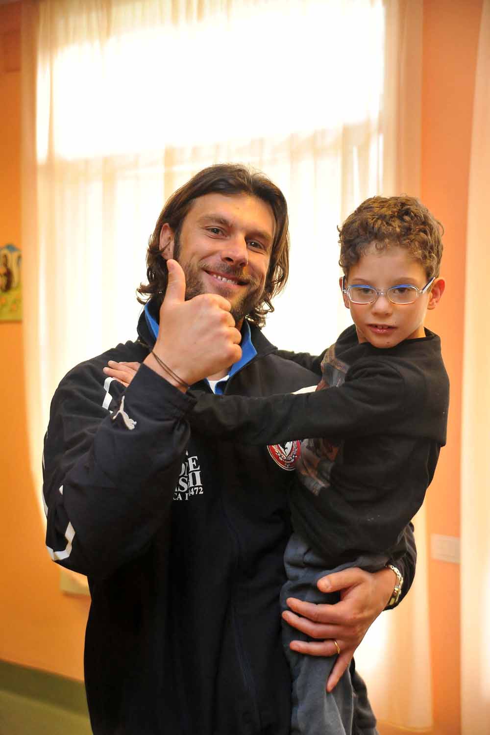Marco Pecorari sorride con uno dei bambini dell'ambulatorio
